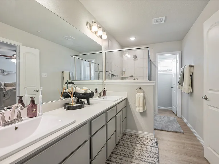 Dual vanity with undermount sinks, a spacious mirror, and overhead lighting