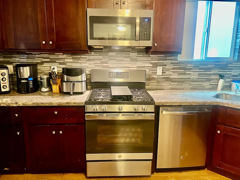 Full Kitchen w/ stainless steel appliances including Air Fryer Oven, Dishwasher, Refrigerator w/ Ice maker and built-in Microwave. Marble counter tops, Dark wood cabinets, Bamboo hardwood floors through out the Home. Kitchen has cooking essentials.