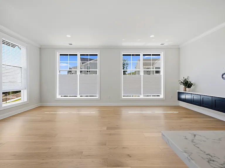 Airy, spacious living room features gorgeous natural light, custom built-in cabinetry, and storage closet.