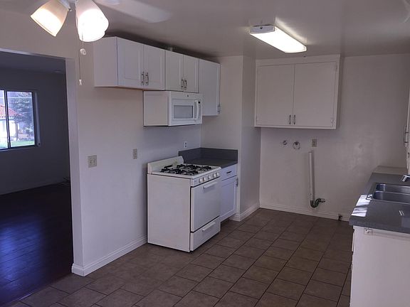 Kitchen showing Microwave, Range and Refrigerator Area with Washer-Dryer Hook-ups and Sink to the Right.