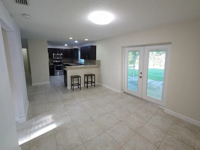 Dining room with door to outside trellis covered deck. 3rd bedroom to the left