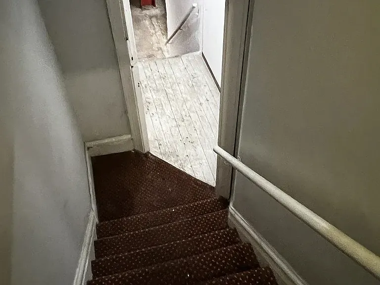 Stairway from 1st floor down to laundry and trash area.