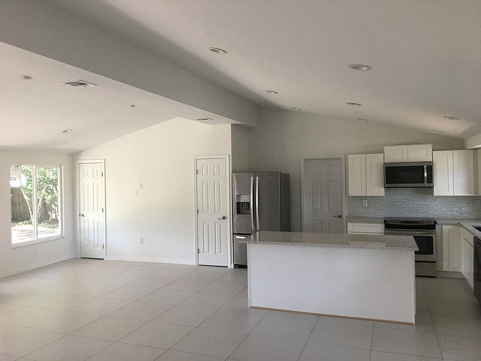Vaulted open concept living room, dining, and kitchen