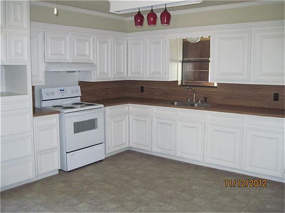 Kitchen with new electric range and recently painted cabinets