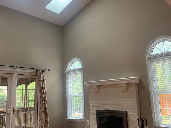 Main living room with high vaulted ceiling , French doors lead to covered deck.