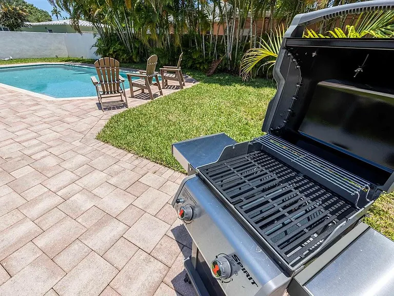 Double sized private fully fenced lot with patio, outdoor dining table, and heated pool.
