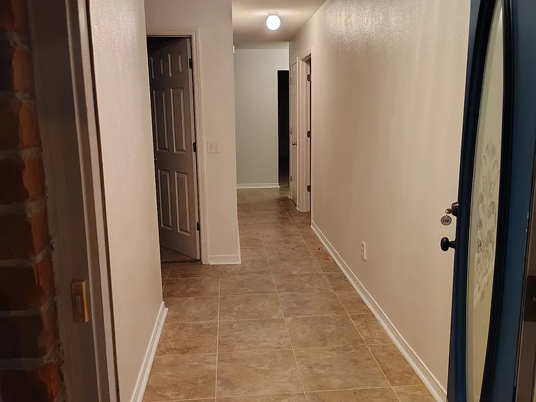 View from front door toward kitchen. Doorway on left is to Bedroom #2.