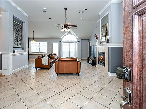 The front door leads you into this open concept floor plan. Living area is tiled with a warming gas fireplace and high ceilings with recessed lighting