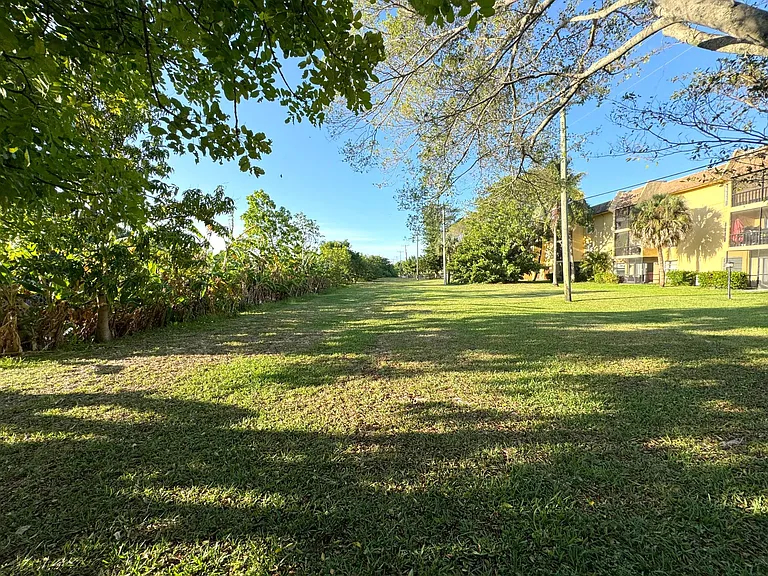 Large grassy yard with view of condo