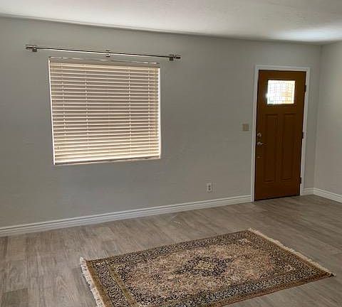 Aah, the living room. New stainless steel drapery rods await your choice of draperies. The soft, driftwood floor await your rug and furniture. Note the nice new white baseboards.