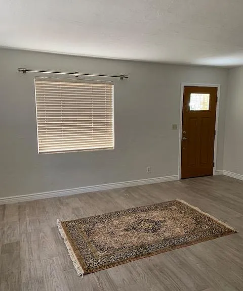 Aah, the living room. New stainless steel drapery rods await your choice of draperies. The soft, driftwood floor await your rug and furniture. Note the nice new white baseboards.