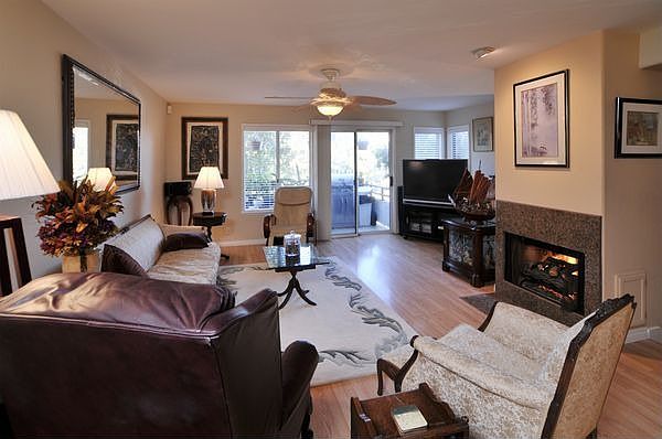 spacious living room with adjacent patio, cozy fireplace, in wall speakers, 