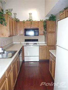 Kitchen featuring cherry laminate flooring,skylight, lots of wood cabinets, all appliances including