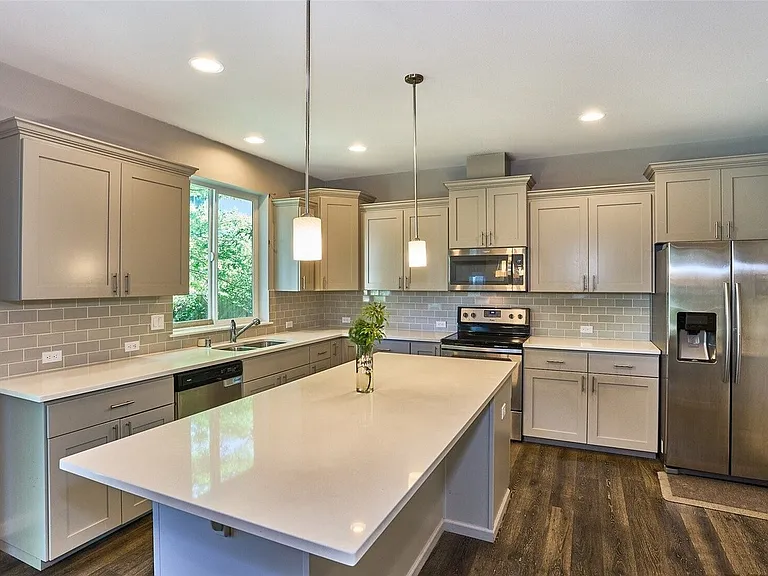 Modern open-concept kitchen featuring high-end appliances, sleek finishes.