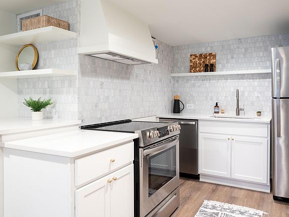 Shaker cabinets, quartz counter tops, and custom, marble tile backsplash.