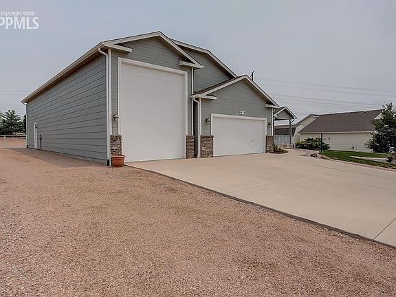 Oversized 2 car garage and a tandem 3 car RV garage w extra parking to the side.