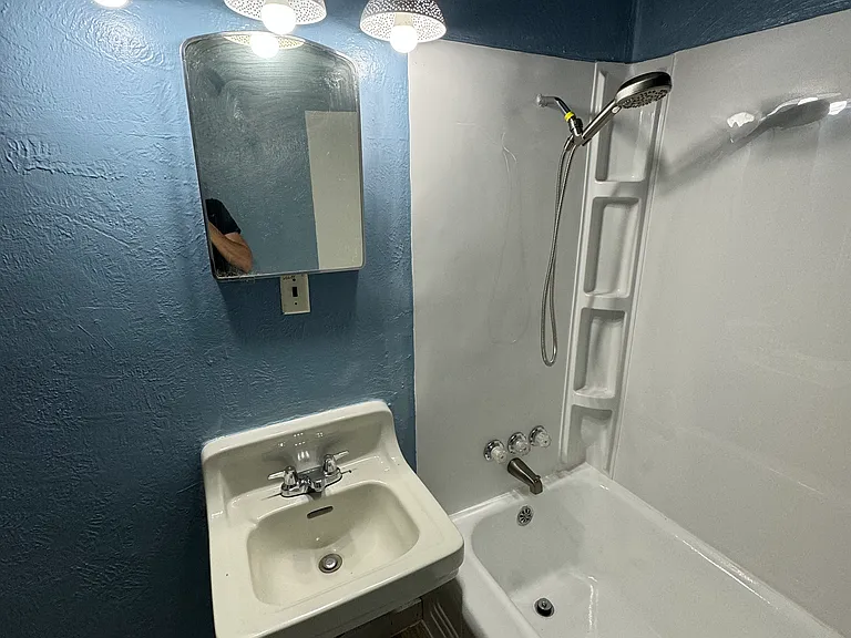 The bathroom has been completely redone including a new surround with shelving and removable/ adjustable shower head.