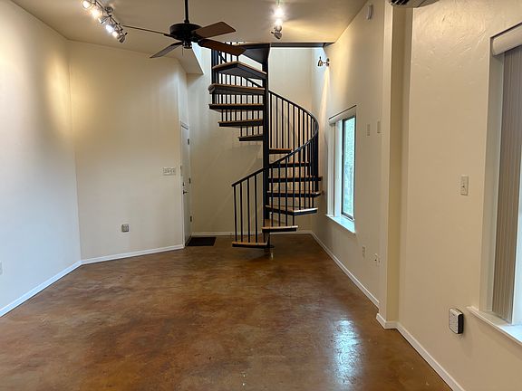View of the living area, entrance, and staircase from the kitchen.