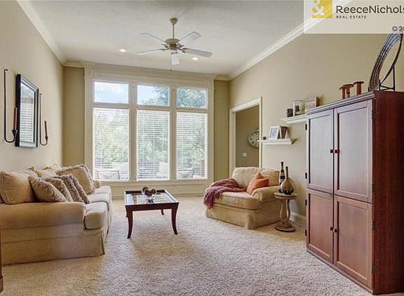 Great room with wall of windows overlooking trees and golf course.