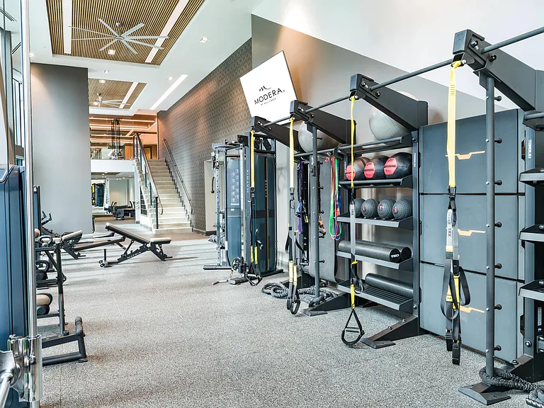 An advanced fitness center at Modera McGavock, featuring strength and functional training spaces.