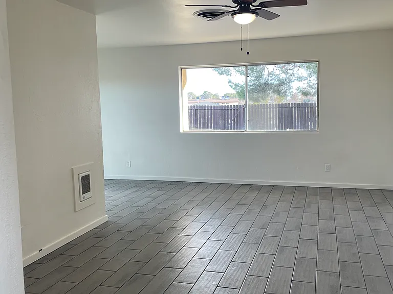 Living Room with Ceiling Fan and New Wood Like Tile Flooring