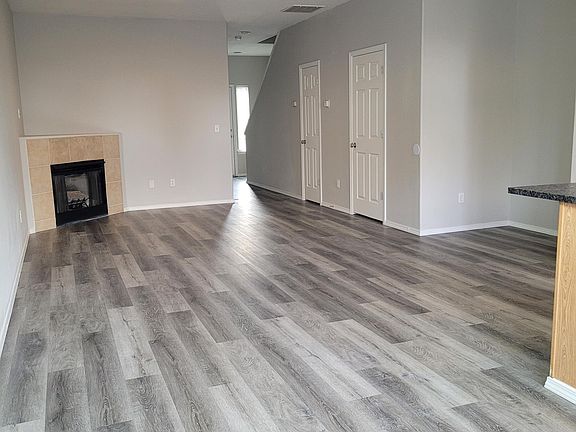 Corner gas fireplace adds instant warmth to the living space. Half bath and closet doors shown on the opposing wall.