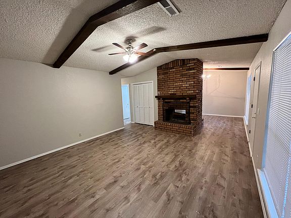 living room with vaulted ceilings and wood beams, gas fireplace dual sided