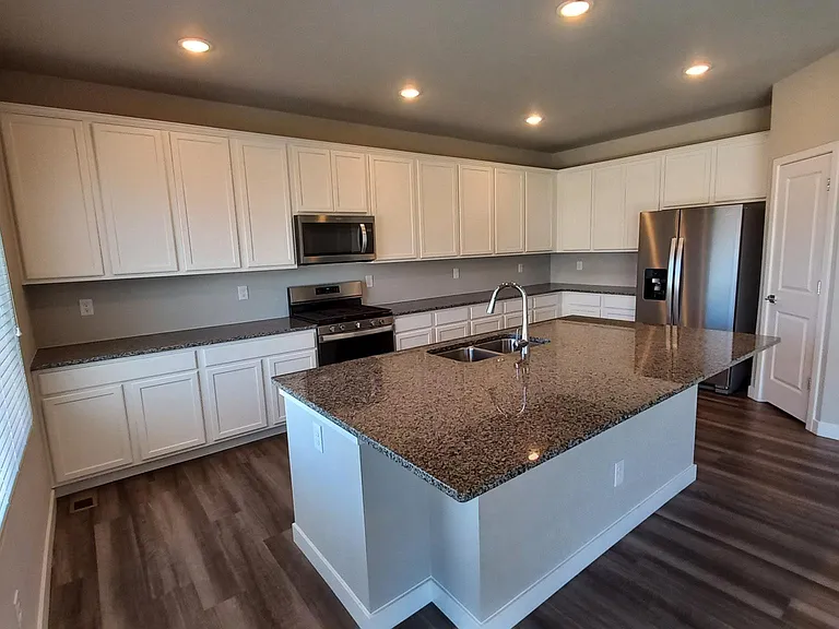 The granite island has room for up to five or six bar-stools: Three to four under the front overhang, plus one on each end.