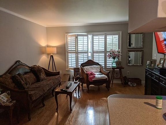 LIVING AREA WITH HARDWOOD FLOORS AND PLANTATION SHUTTERS