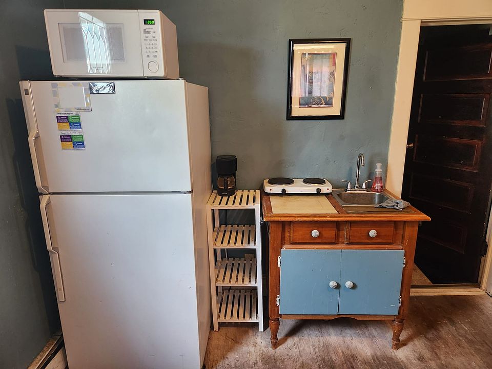 Kitchenette included refrigerator/freezer, microwave oven, 2 burner cooktop, and sink with cabinets.