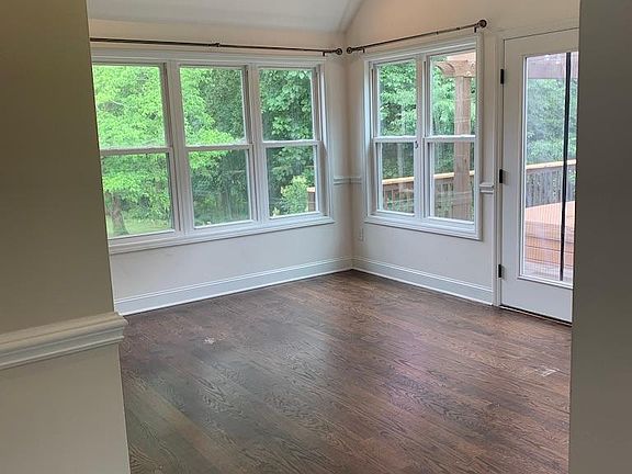 Sunroom. 3 walls of windows. Leads onto the deck.