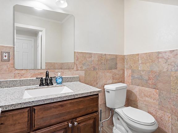 Updated bath with stone-look countertop, under-mount sink, large mirror, and ample vanity storage for daily essentials.