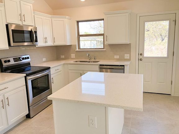 Spaciously island with white quartz counters throughout.