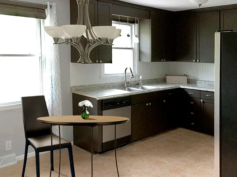 Eat-in kitchen with stainless steel appliances _ dishwasher, large refrigerator, range _ and plenty of counterspace and storage.