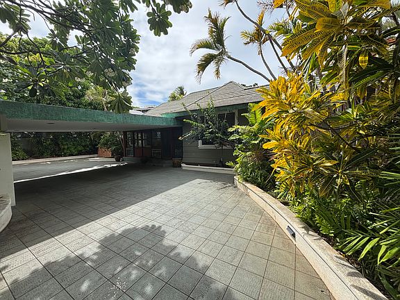 Covered Parking and Front Entrance. Left side of driveway which exits to a second gate.