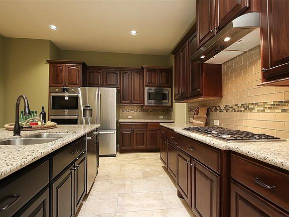 The chef's kitchen has undermount lighting, a five burner gas cooktop and tons of cabinetry.