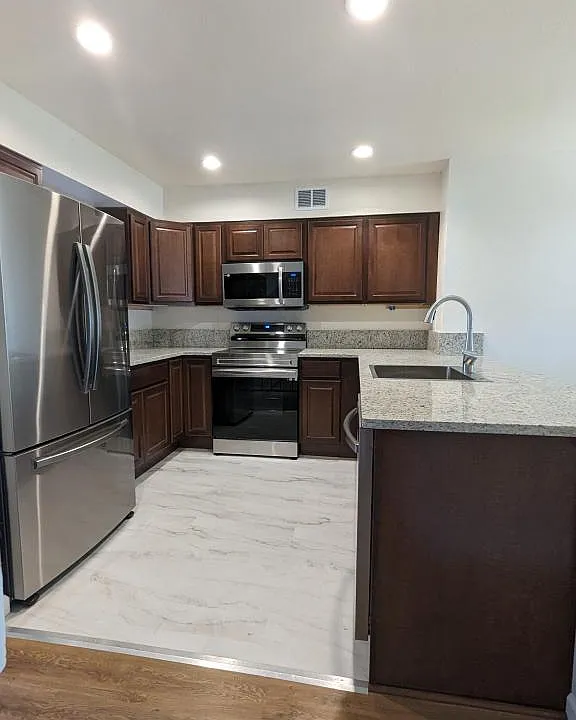 Kitchen with brand new stainless steel appliances, wood cabinets and granite countertops