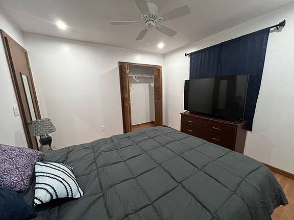 Bedroom 2 with 65" TV 6 drawer dresser and closet with storage shelf