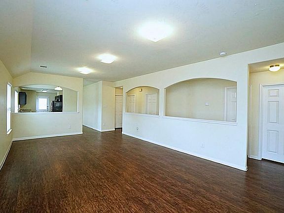 Living room with dining and kitchen with door to back yard.