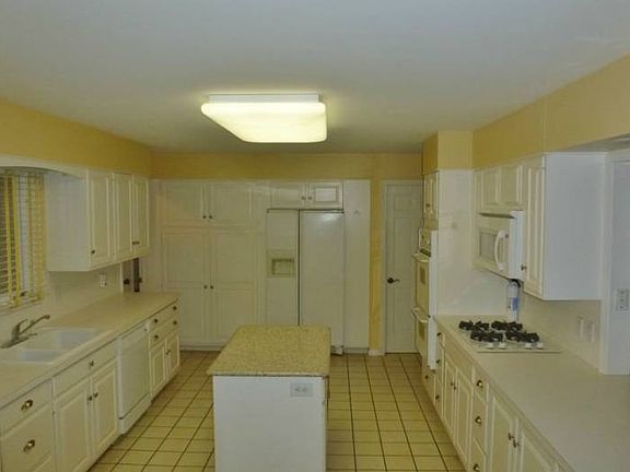 Bright and cheerful kitchen has a granite-topped island and a  peninsula overlooking the family room!  The family chef will enjoy the gas cook-top and the double ovens!