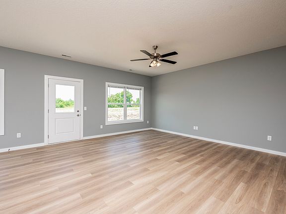 Living room includes vinyl flooring, ceiling fan, central air, energy efficient