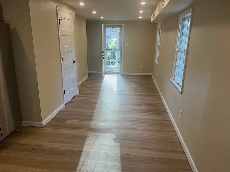 Standing in kitchen by back door looking at front door. Guest bathroom on the left