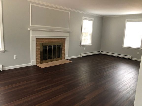 Spacious living room offers an abundance of space for versatile furniture arrangements and comfortable seating. This light filled room provides an inviting atmosphere for relaxation & entertaining.