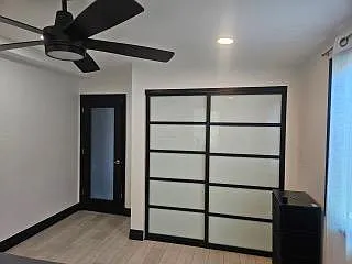 Spacious bedroom featuring a ceiling fan, recessed lighting, and a sliding closet door for easy storage access.