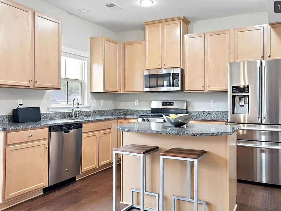 elegant kitchen with an island, stainless steel appliances, recessed lighting and wood plank flooring