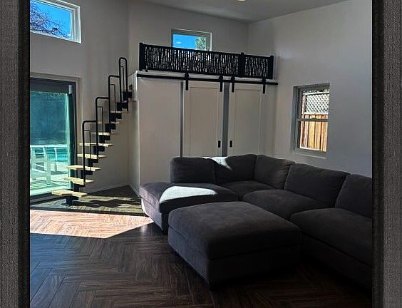 looking from the kitchen to the living room the small room, the loft, and the pool