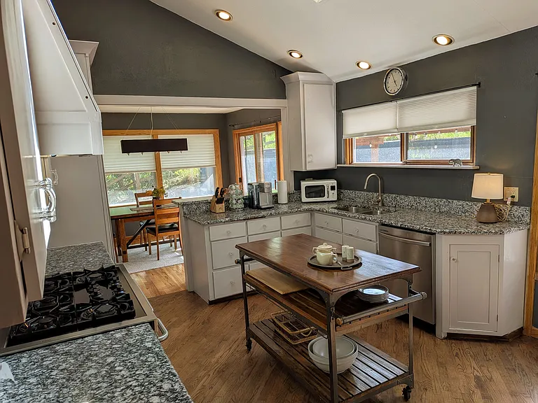 Kitchen with granite counters, stainless appliances, 5 burner gas stove with 2 ovens, and casual seating area.