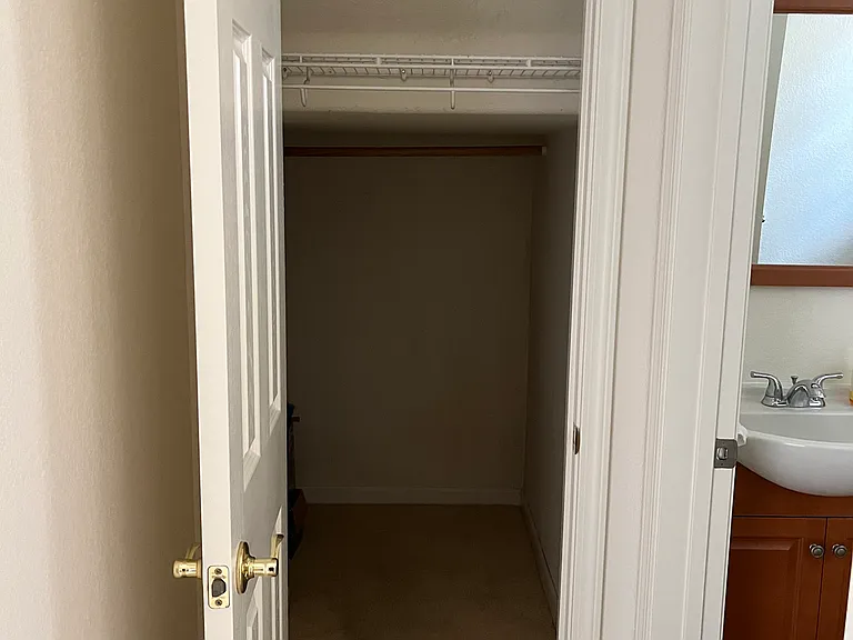 Wrap- around closet under stairs next to half bath across from kitchen