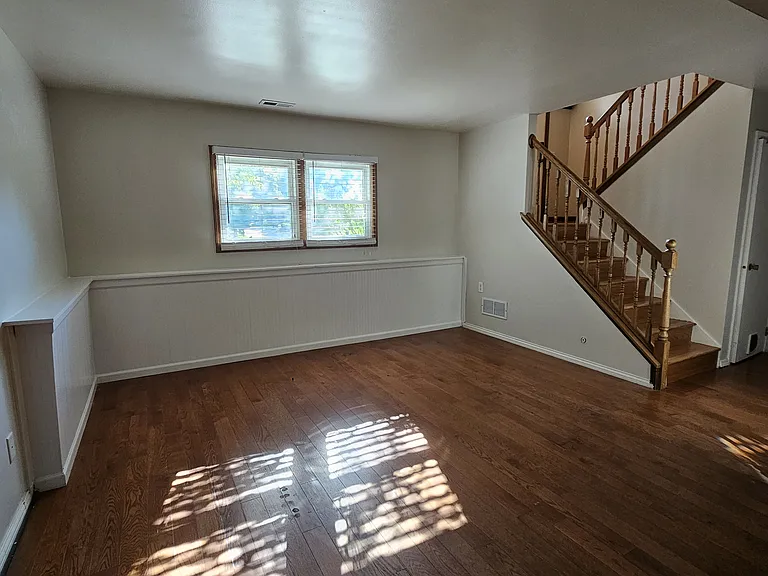 Lower-level open space w/ 2" white window blinds, white wall shelf, for gym or office or study
