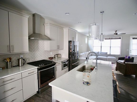 Stone kitchen Island, stainless steel appliances. custom blinds